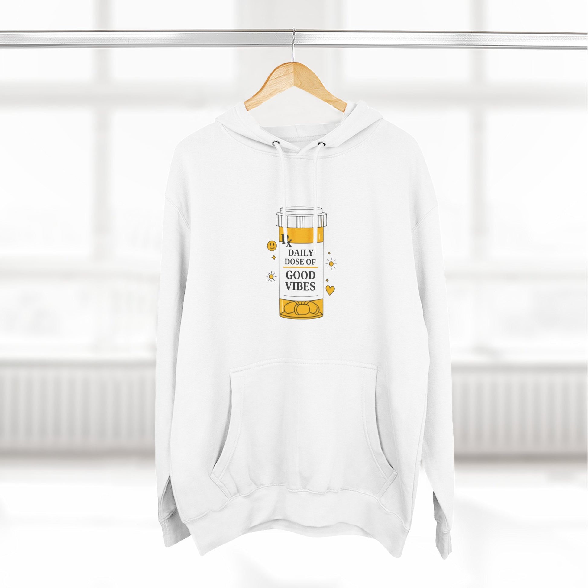 White hoodie with a daily dose of good vibes  design on a hanger against a white background