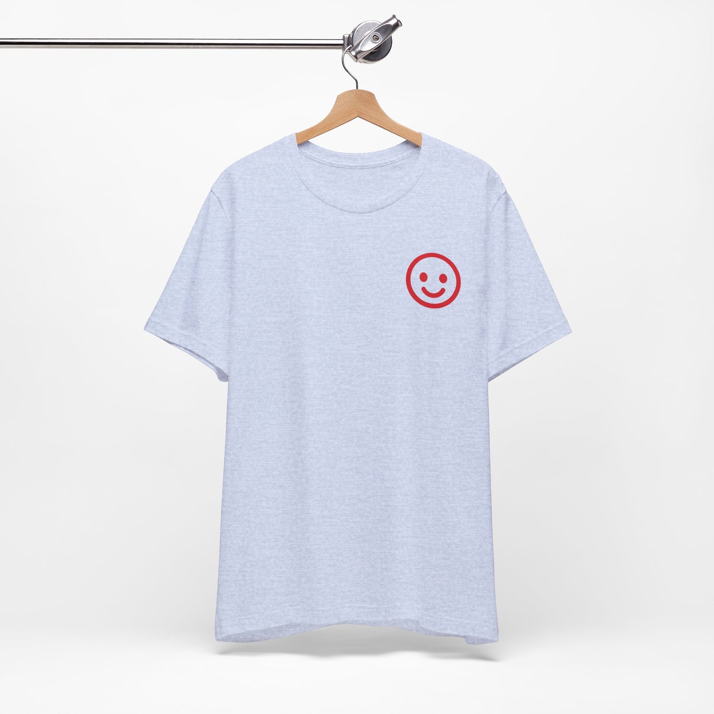 Light blue t-shirt with a red smiley face on a hanger against a white background