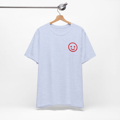 Light blue t-shirt with a red smiley face on a hanger against a white background