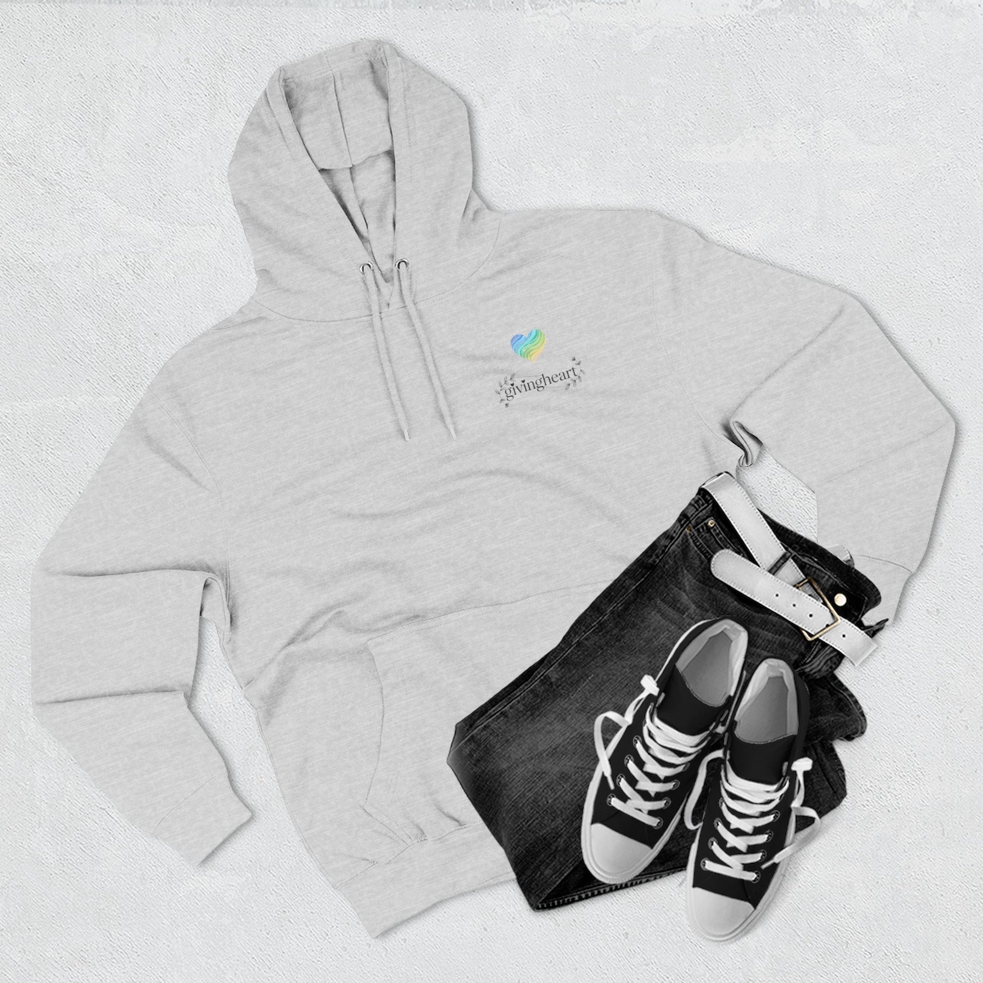 Gray hoodie with a blue/green/yellow heart logo logo, black jeans, and black sneakers on a light gray background