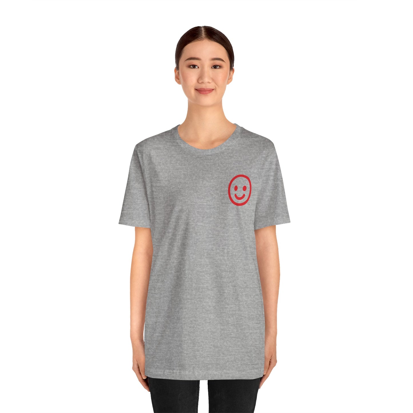 Girl wearing a gray t-shirt with a red smiley face on a white background