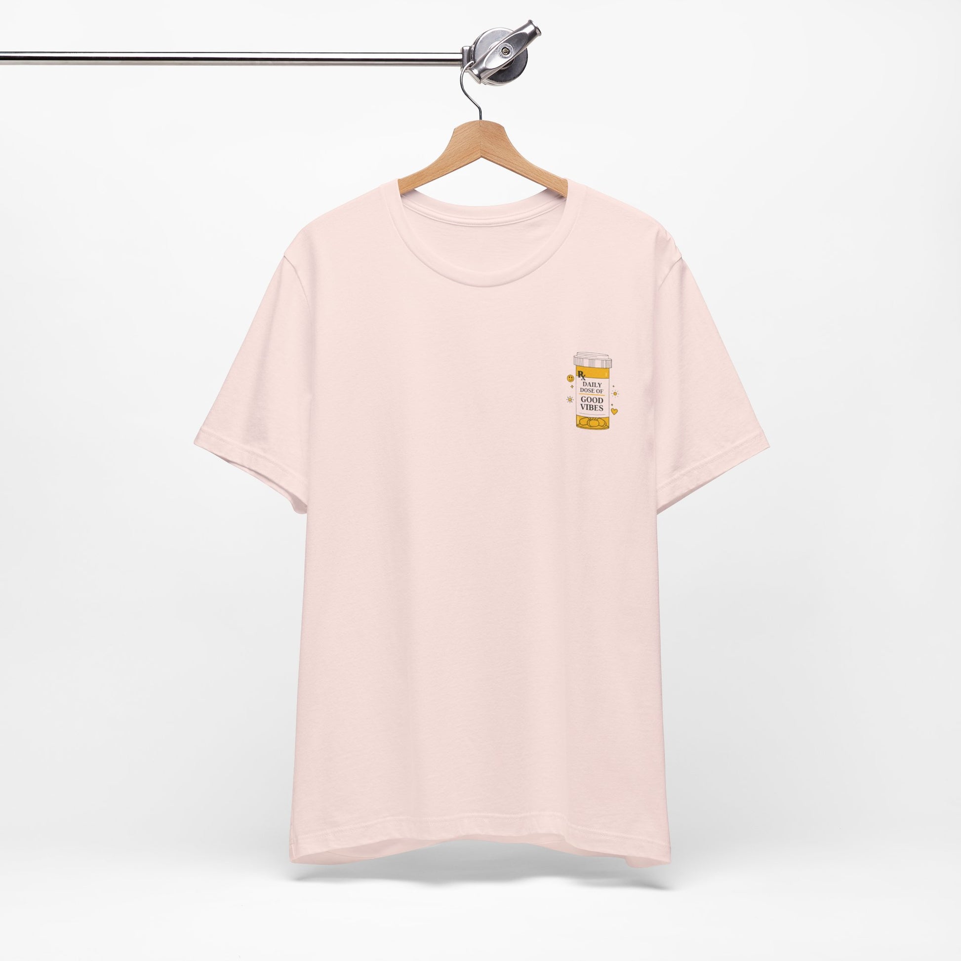 Pink t-shirt with a prescription bottle good vibes  design on a hanger against a white background