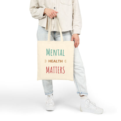 Person holding a tote bag with 'Mental Health Matters' text on a white background