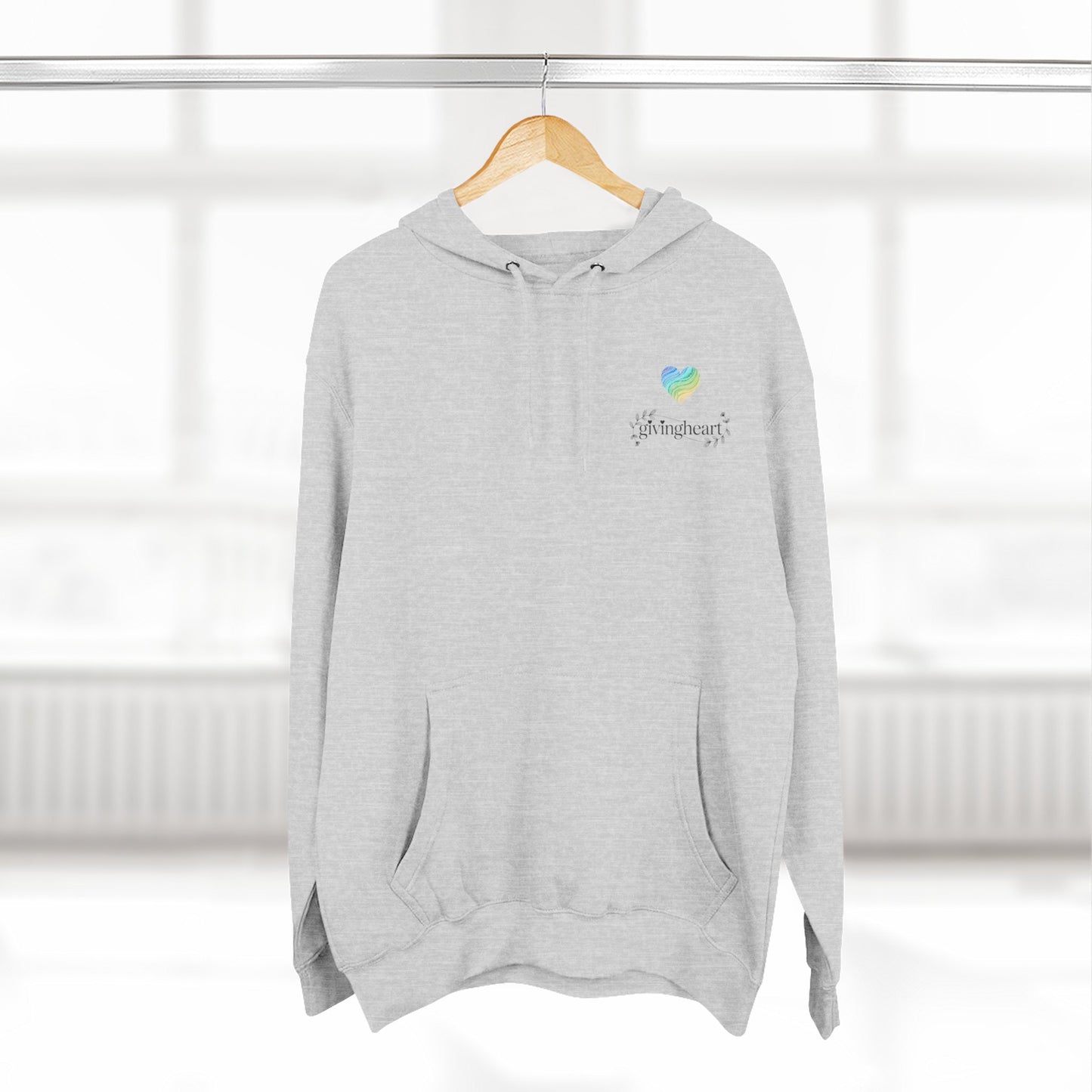 Gray hoodie with a blue/green/yellow heart logo on a wooden hanger against a white background