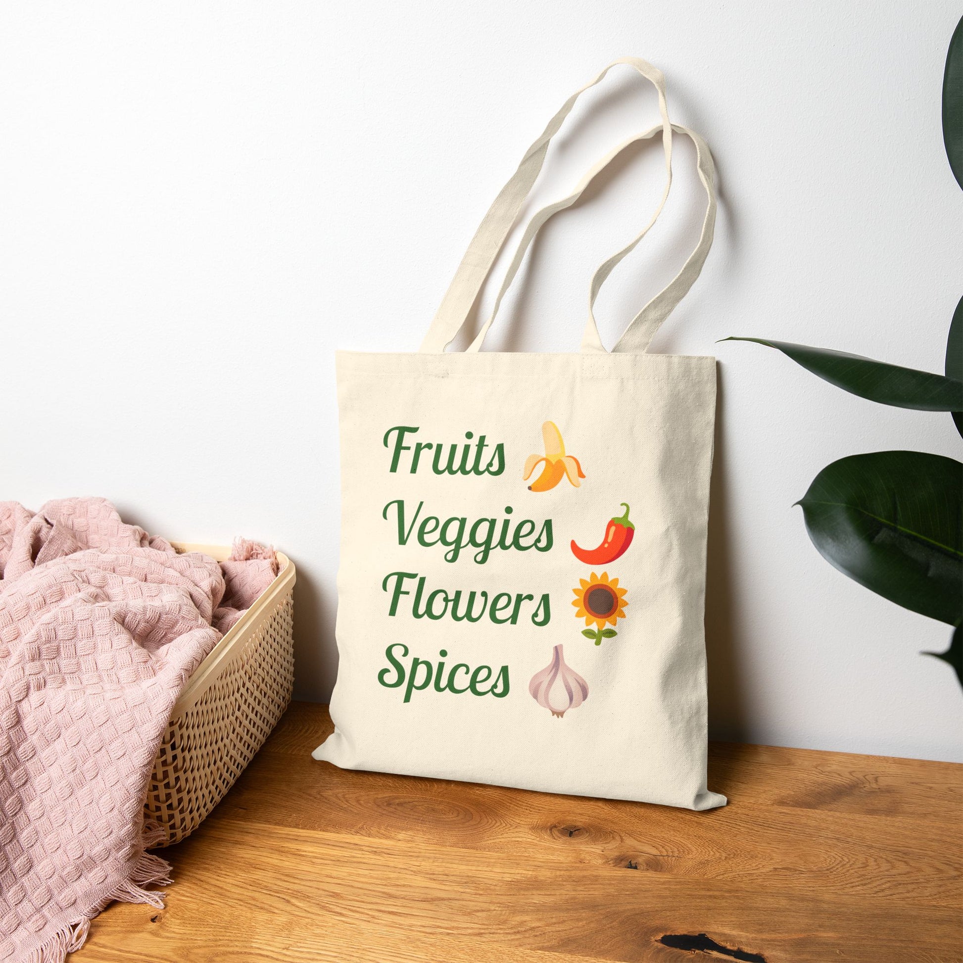 Tote bag with 'Fruits Veggies Flowers Spices' text and graphics on a wooden surface.
