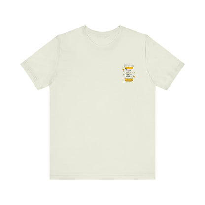 beige t-shirt with a small prescription bottle good vibes graphic on the chest against a white background