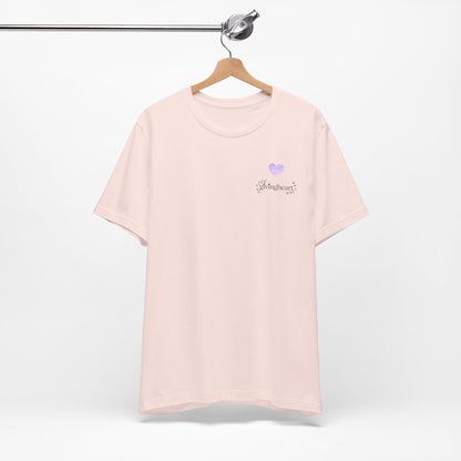 Pink t-shirt with a  lilac heart logo on a hanger against a white background