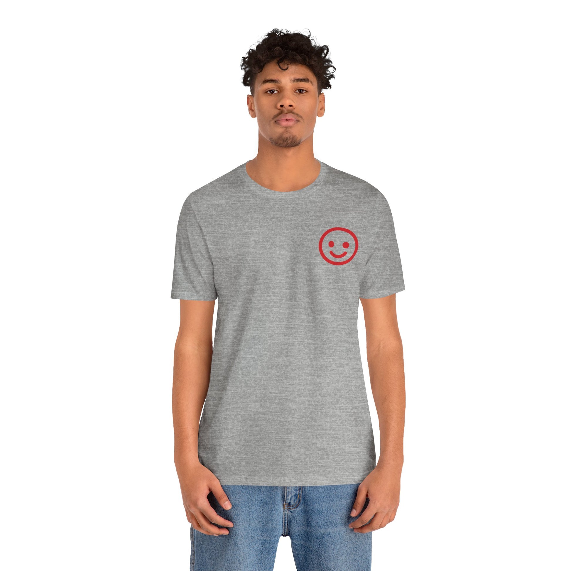 Person wearing a gray t-shirt with a red smiley face design on a white background