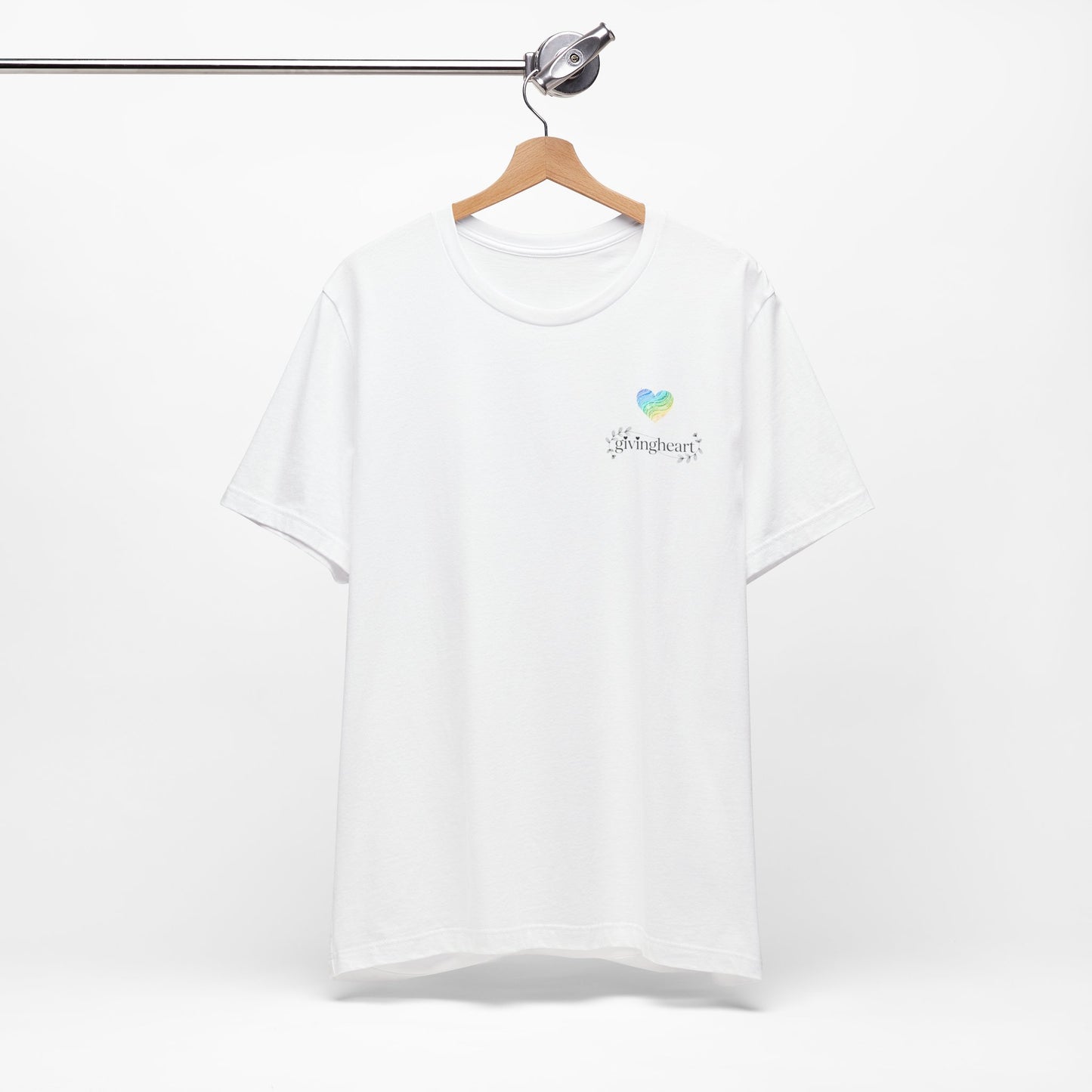White t-shirt with a blue, yellow, and green heart logo on a hanger against a white background