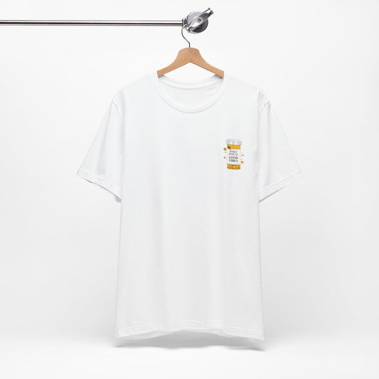 White t-shirt with a small prescription bottle good vibes graphic on a hanger against a white background