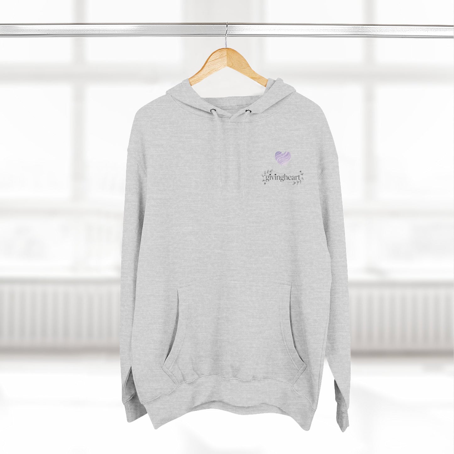 Gray hoodie with a lilac colored heart logo on a hanger