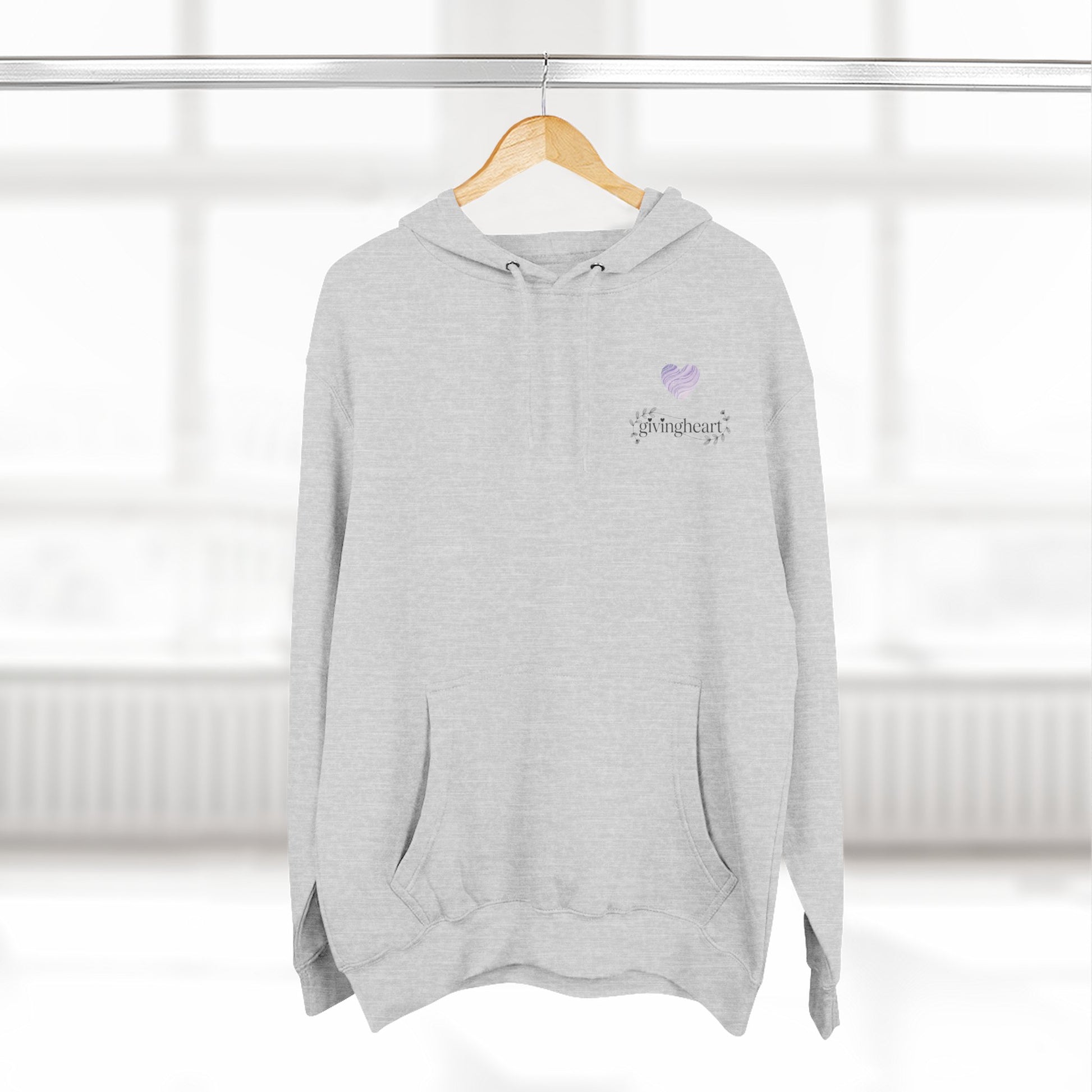Gray hoodie with a lilac colored heart logo on a hanger